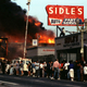 Residents in Los Angeles gather and watch businesses burning at intersection of Pico Boulevard and Hayworth Avenue on April 30, 1992, during the riots that broke out following the not guilty verdict for policemen on trial for beating Rodney King. (Lindsay Brice/Getty Images)
